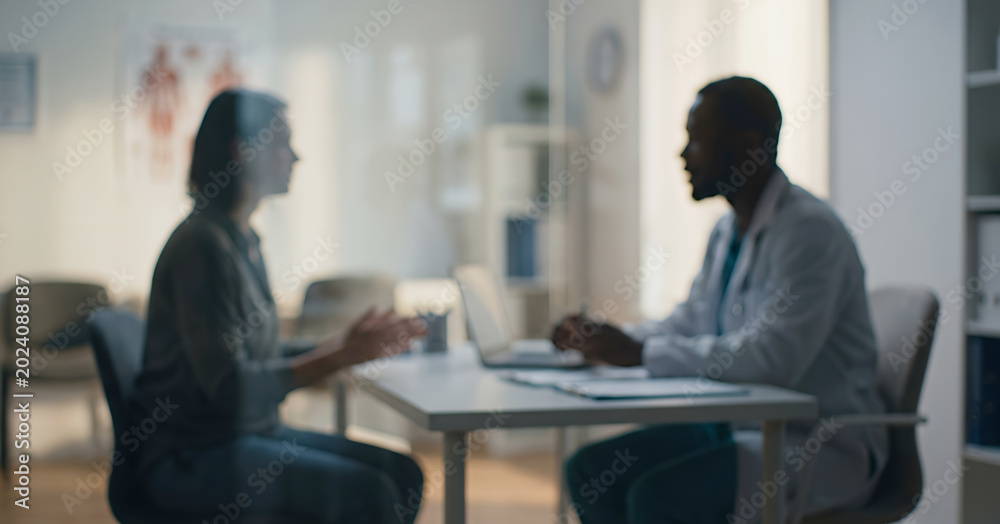 Fototapeta premium A healthcare professional engaged in a conversation with a patient in a medical office. The atmosphere is calm and focused on patient care.