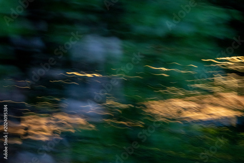 Schilderij op canvas Abstract long exposure with vibrant gold light trails weaving through deep forest green and navy blue