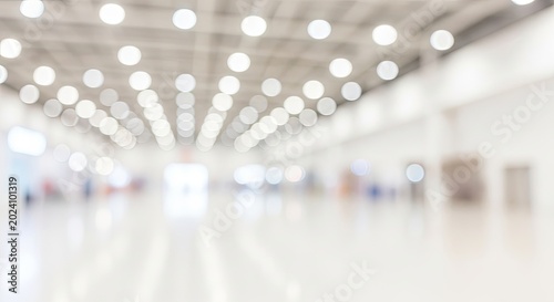 Abstract blurred background of a modern exhibition hall with bright ceiling lights.