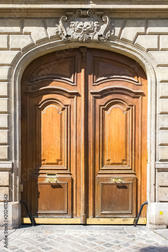 Paris, a wooden door rue de Babylone, typical building in the 7th arrondissement, a luxury district
