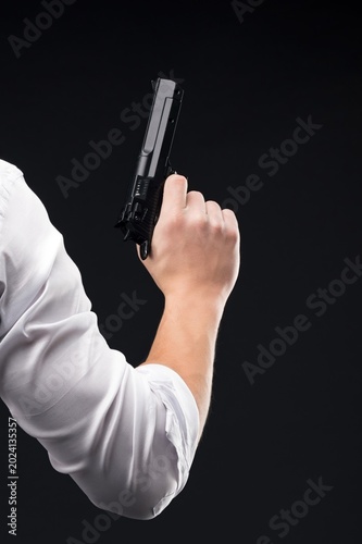 Man in white shirt holding a firearm in the air