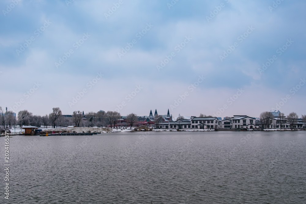 Obraz premium Snow Scenery of Hailong Lake Scenic Area in Meihekou, Jilin Province, China – Urban Ecological Park and Lakeside Landscape Covered in Late Spring Snow – April 4, 2026