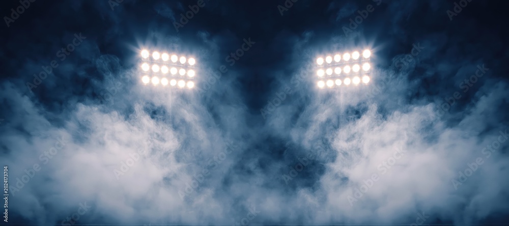 Naklejka premium Stadium floodlights illuminating dark smoky arena at night