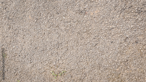 Beige sandy asphalt texture with fine aggregate and natural tone. Warm, coarse grain with an outdoor feel. Perfect for construction, pathway, or earth-toned design backgrounds.