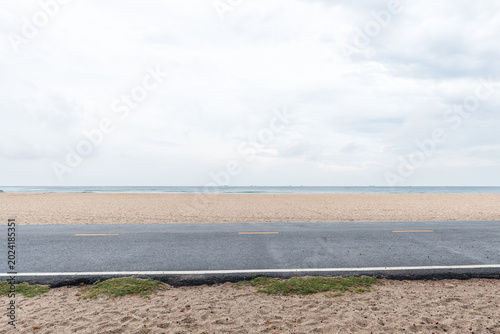 Side view of asphalt road with beach on sea and beautiful sky.