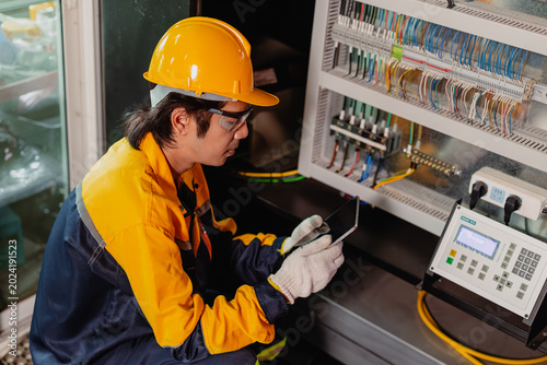 Industry Electrician, Engineer electricity technician man check electric wire at industry machine.