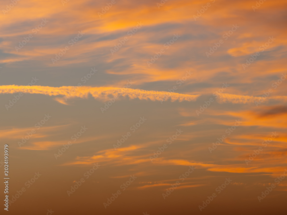 Fototapeta premium Soft orange sunset clouds in peaceful evening sky background