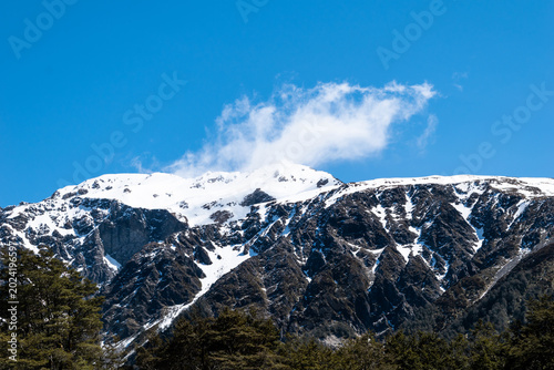 Bild auf Leinwand Arthur's Pass, New Zealand - October 26 2019: Close Up of Mountain with Cloud Fr