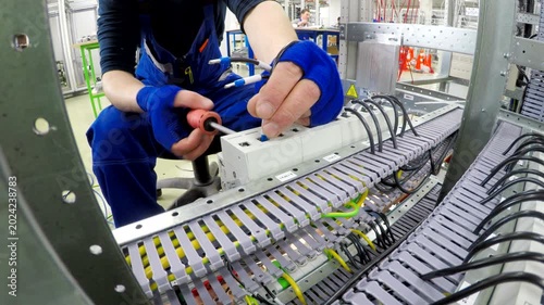Electrician Installing Wiring in Industrial Control Cabinet