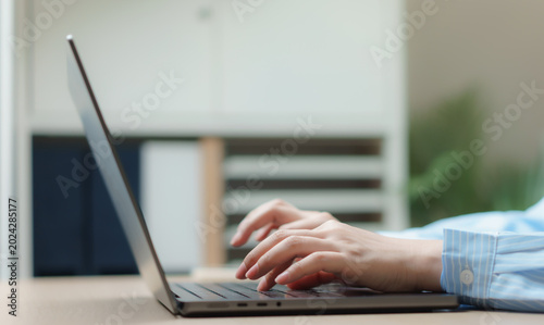 Valokuva Close up woman hands typing on laptop keyboard while working on computer in modern office workspace