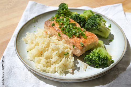 Salmon fillet with broccoli rice and herb garnish, healthy meal rich in high-quality protein, omega-3 fatty acids, and vitamins, cooking and eating for health, selected focus