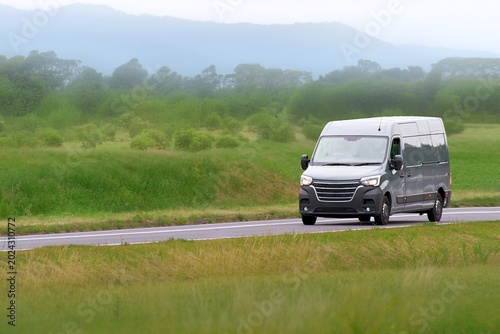 Konstfotografi Delivery service van driving along a green meadow road