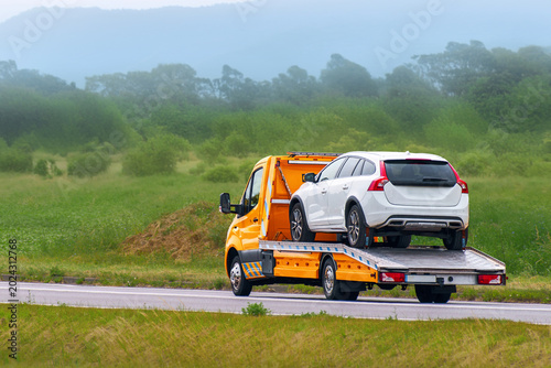 Obraz na płótnie Heavy duty wrecker transporting a car on a flatbed