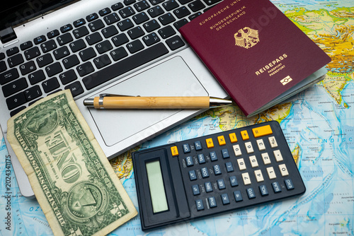 ravel planning concept with passport, calculator, one dollar bill and pen on world map symbolizing vacation budget, trip preparation, tourism expenses and international journey organization
