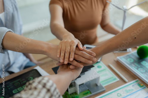 фотографія A close-up image of a group of business leaders shaking hands after completing a workshop on ESG strategic commitments and the Sustainable Development Goals report