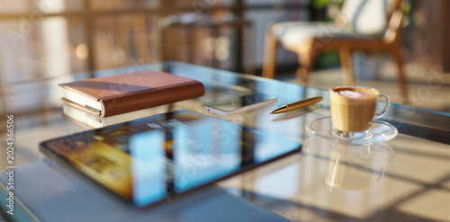 Coffee cup laptop and leather journal on desk in sunlit modern workplace interior with workplace business sunlight interior technology notebook stationery productivity