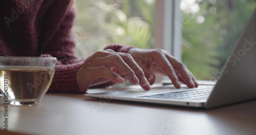 Hand of Asian woman using laptop, Asia business typing work on computer at home