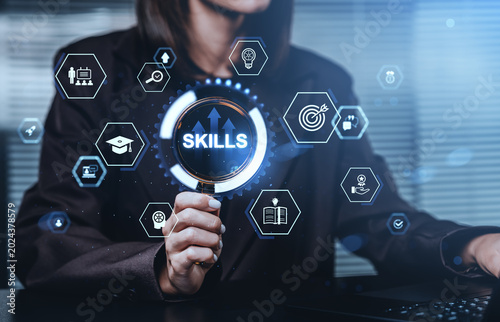 Foto Business person holding magnifying glass with skills icons aroun