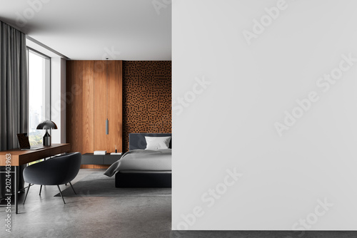 Modern bedroom interior with wooden accents, patterned partition, workspace and wide empty wall mockup for poster or design template display in calm architecture. 3D Rendering