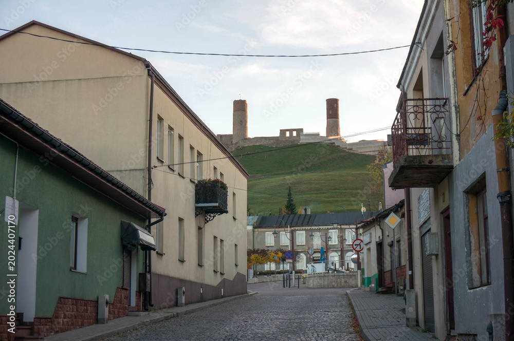 Fototapeta premium Staszica Street leads to main town square. Towers of Upper Castle in background. Chęciny, Poland.