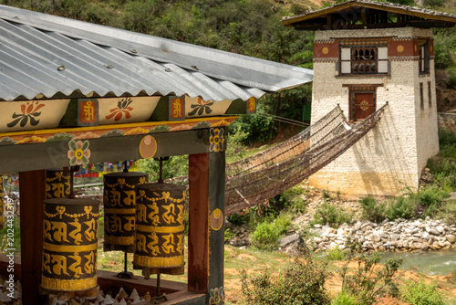 Tachog Lhakhang Bhutan, Tachog Lhakhang’s old bridge built by Thangtong Gyalpo in 1433 with prayer wheels in foreground