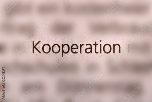 Tableau sur toile Der Begriff  kooperation  in der Zeitung gedruckt und durch Umgebungsunschärfe