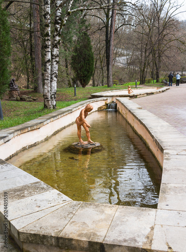 Kislovodsk. Caucasus. Sculptures of children bathing in small pools of thermal water in the Lower natural resort park of Kislovodsk on spring day. Health-improving walks through the beautiful old park