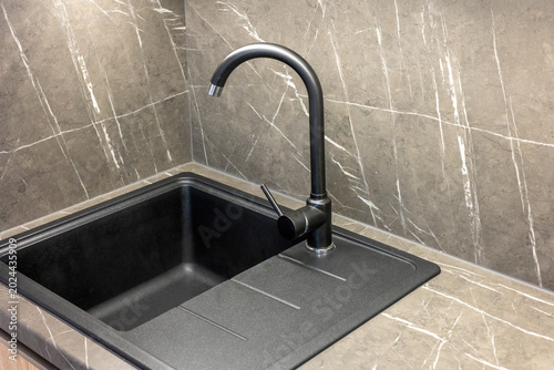 Top view of a sink with a modern black faucet. Kitchen detail. Horizontal.