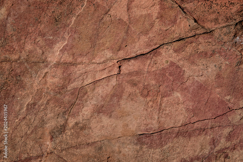 Photos Full frame ancient red rock surface with natural cracks in warm earthy tones under harsh sunlight