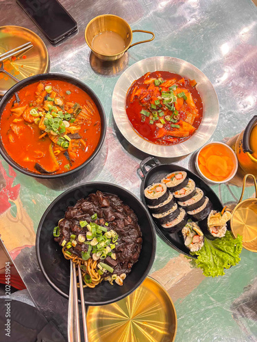 Korean foods served on a dining table with Tteokbokki,tofu and kimchi soup pot,Kimbap,Jajangmyeon