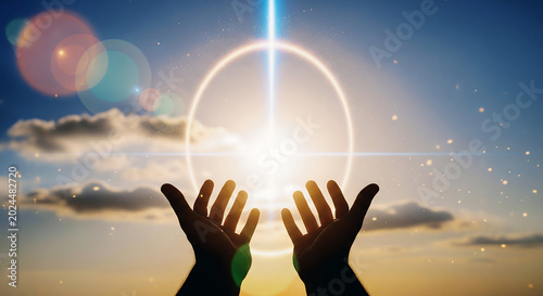 Hopeful hands reaching towards a glowing circle in the sky during a vibrant sunset, symbolizing new beginnings and spiritual connection