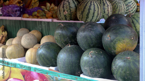 Photos Vibrant Assortment of Fresh Watermelons and Melons Displayed at an Outdoor Marke