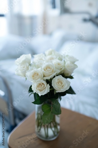 Bouquet of white roses on a hospital bedside table, a symbol of hope