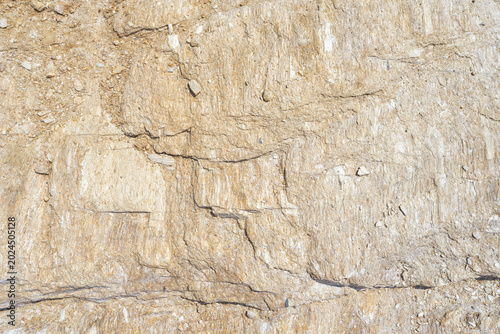 Close-up of natural rock texture with rough stone surface and detailed geological structure, abstract beige background ideal for design, backdrop, wallpaper or graphic composition