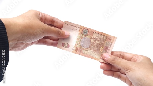 Obraz na płótnie Woman holding a 2 Ukrainian hryvnia banknote with two hand, isolated on a white background