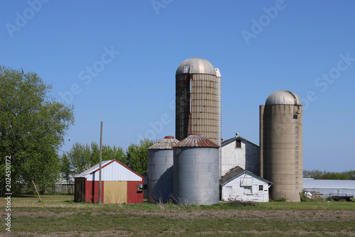 Obraz na plátně Abandoned farm in Mount Pleasant, Wisconsin with two grain bins and a pair of co