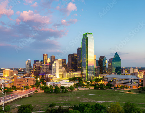A stunning panoramic view of the Dallas skyline at dusk, showcasing its modern architecture against a vibrant, colorful sky.