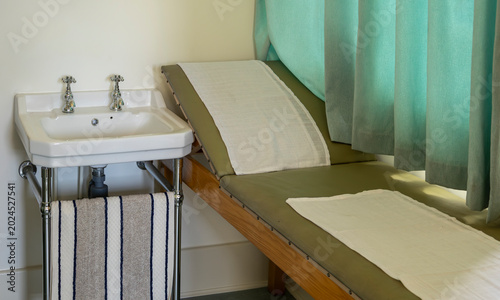 Clinical Examination Room With Sink, Examination Couch and Privacy Curtain in Vintage Clinic
