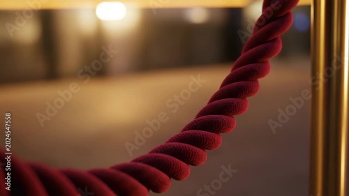 Red velvet rope barrier in a softly lit indoor environment  