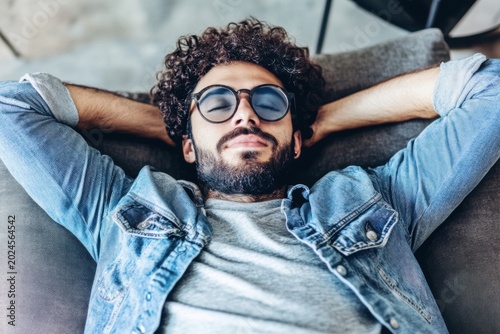 Man with Curly Hair and Glasses Relaxing on Couch