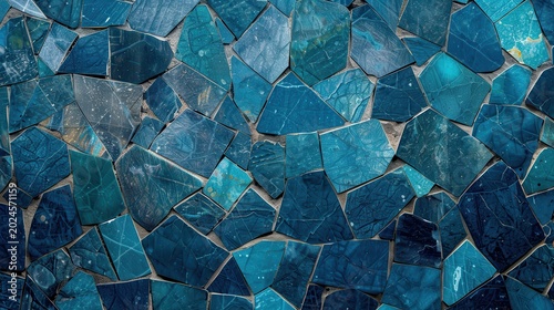 Blue mosaic tiles arranged randomly, showcasing various shades from light to dark blue, creating a textured pattern with a serene, calming atmosphere