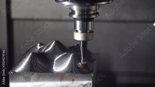 Industrial footage of a CNC milling machine finishing mold parts surface using an indexable tool with a one-way cut direction.