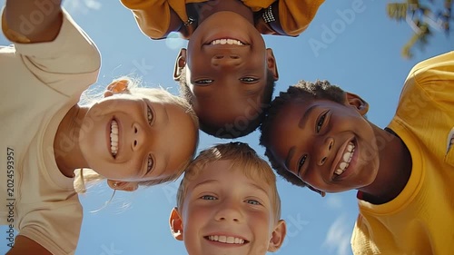Four children of different ethnicities, smiling, heads together