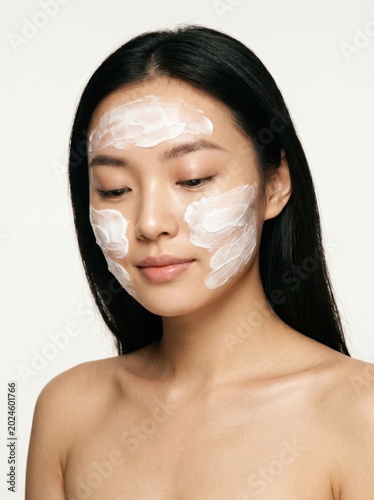 Young asian woman with a clay face mask for skin care