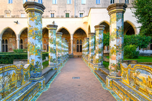 The famous Cloister of Santa Chiara with ornate ceramic tiled columns and benches in the historic center of Naples, Italy