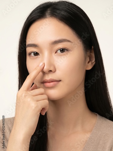 Young asian woman touching her nose for skin care concept