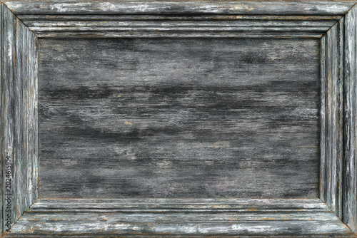 A close-up of a weathered wooden frame with a distressed finish