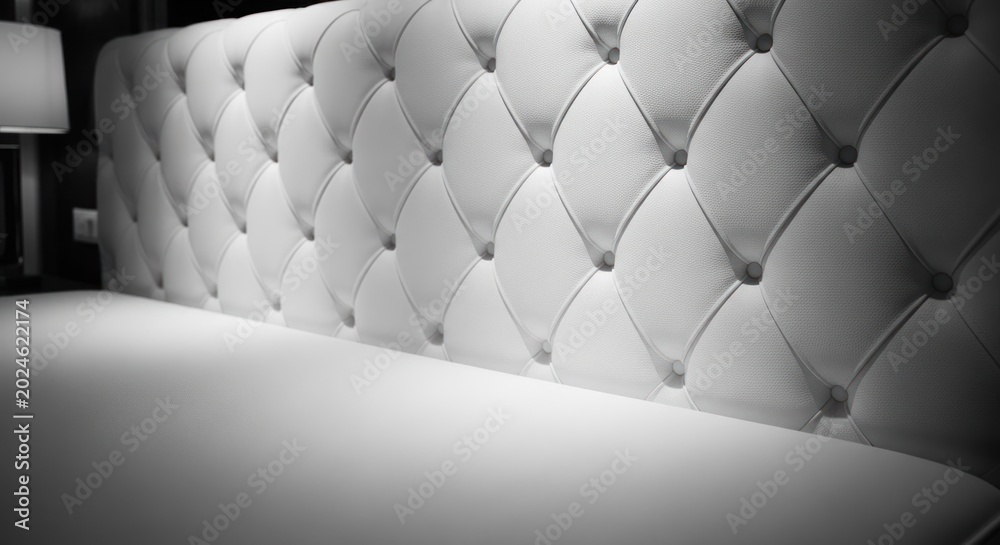 Fototapeta premium Luxurious Tufted White Headboard and Bedding Closeup.