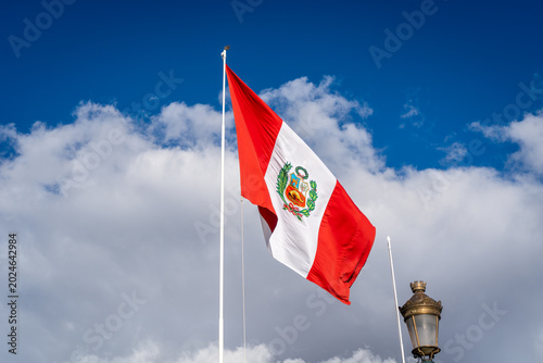 Peruvian National Flag Waving Against a Bright Blue Sky