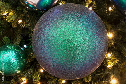 New Year background balls and garland on the tree close-up